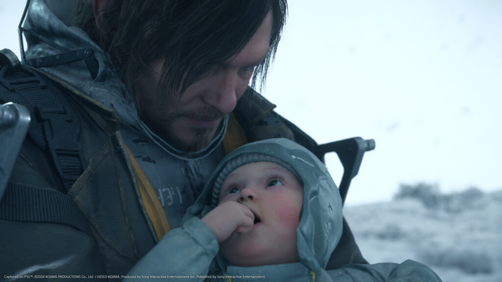Sam Porter Bridges holding a baby while standing in a snowy environment in Death Stranding 2: On the Beach